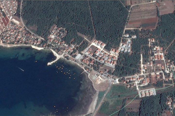 Na slici se vidi cijelo naselje Karigador sa poljima i šumama oko njega. Slika prikazuje naselje sa velike visine te je ona izrađena pomoću satelita Google Maps-a.